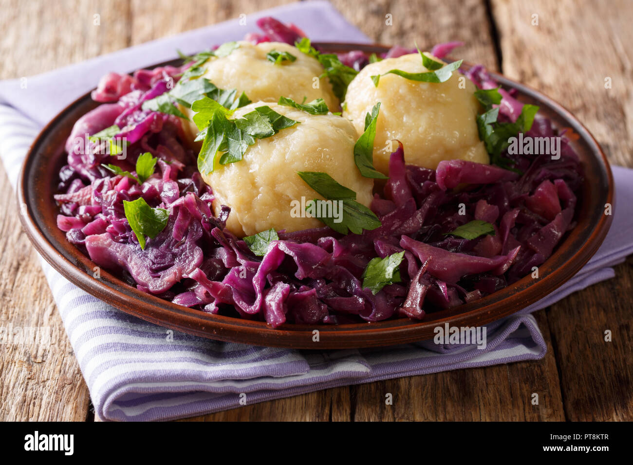Cibo vegetariano gnocchetti di patate con stufato di cavolo rosso insalata di close-up su una piastra sul tavolo orizzontale. Foto Stock
