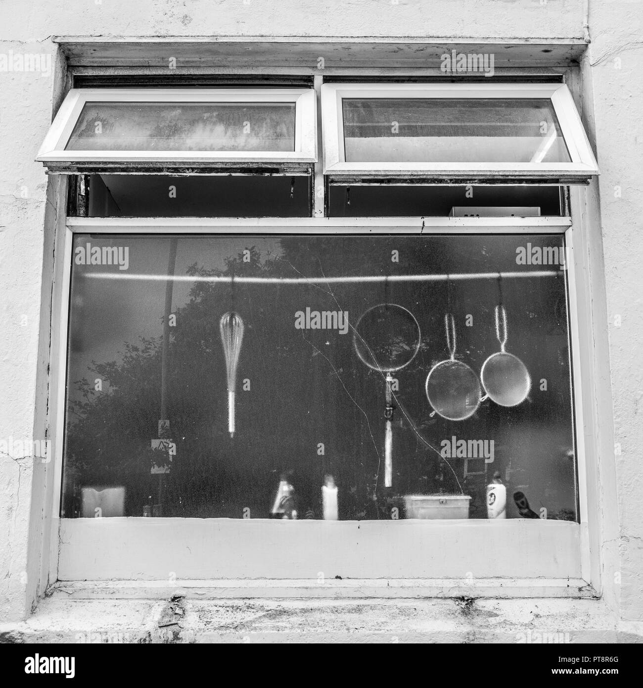 Appannata posteriore finestra della cucina di un cinese da asporto in Newquay, Cornwall. La resa in bianco e nero di PT8R6F. Foto Stock