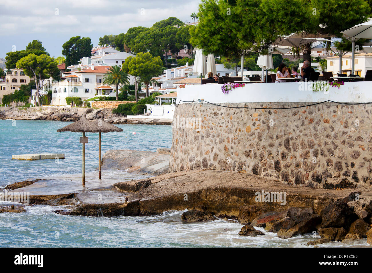 ALCUDIA, Maiorca, SPAGNA - Settembre 26th, 2018: le persone godono di pomeriggio di sole sulla terrazza di un ristorante su Cala Poncet spiaggia vicino a Port d'Alcudia. Foto Stock