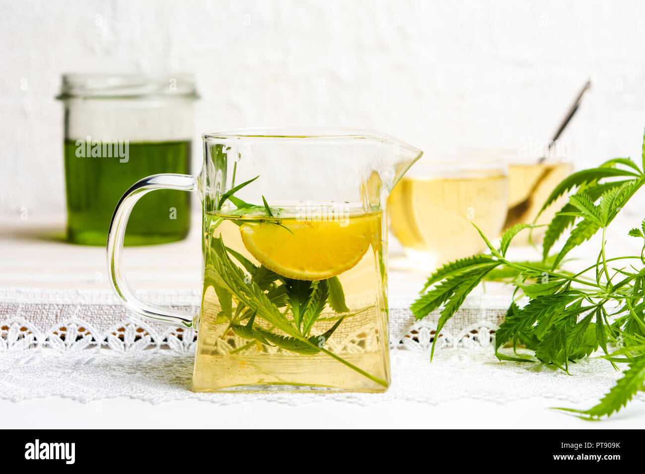 La Cannabis tè con limone e foglie di marijuana in un bicchiere Foto Stock