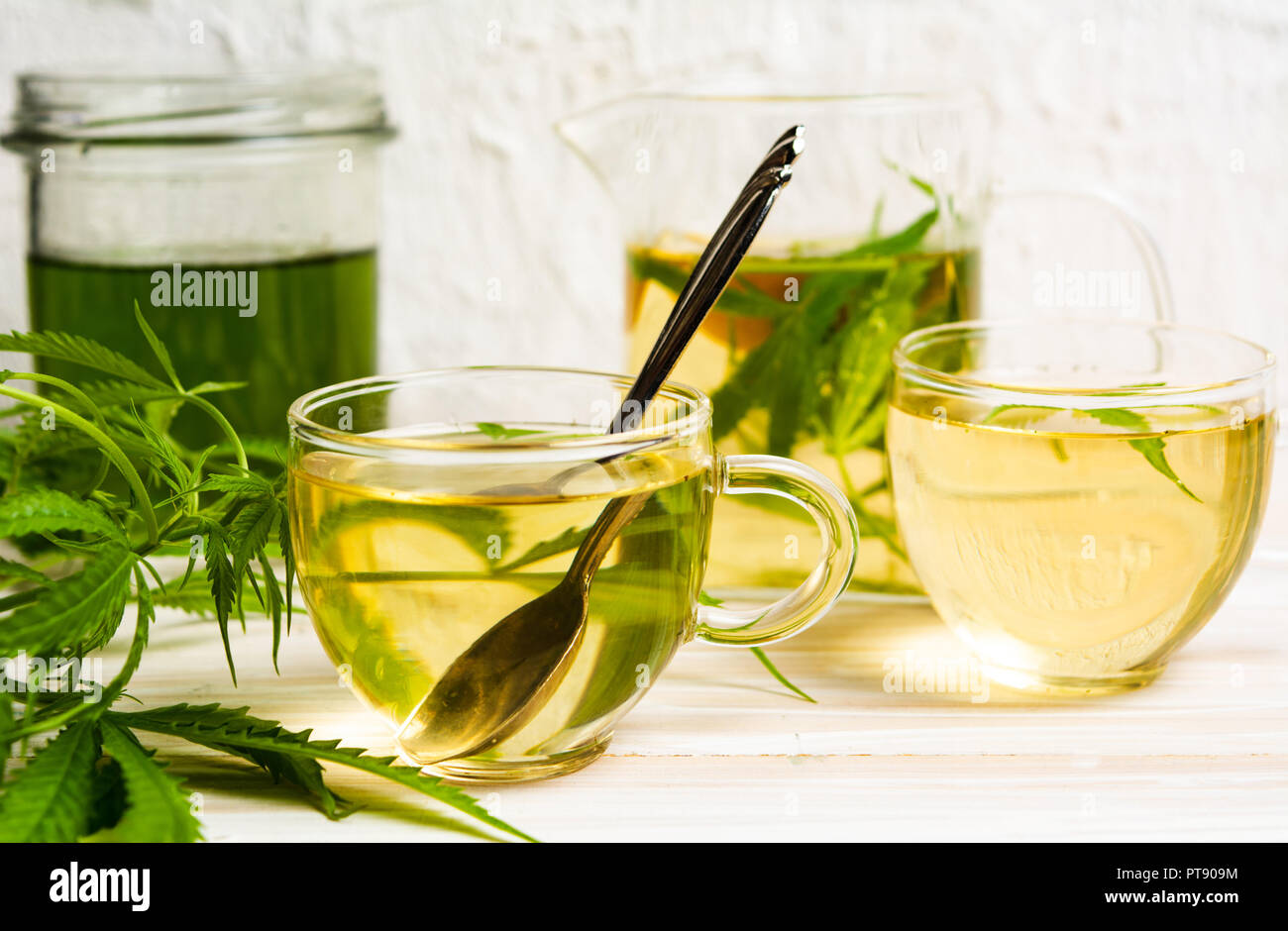 La Cannabis tè con limone e foglie di marijuana in un bicchiere Foto Stock