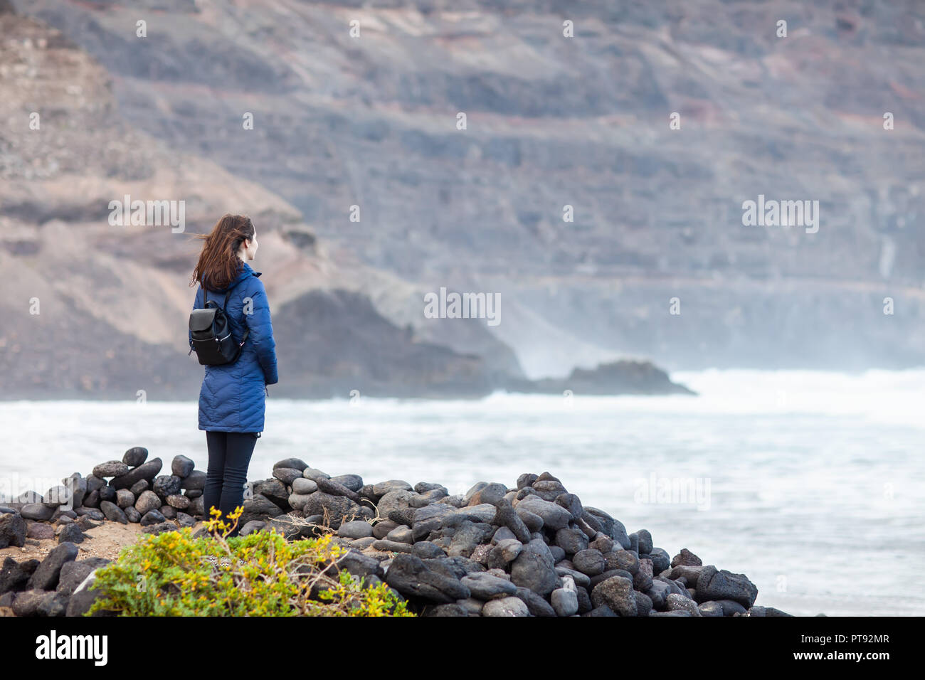 Giovane donna di viaggiatori godere oceano nero sulla spiaggia vulcanica a Lanzarote, Isole Canarie, Spagna. Sfondo di viaggio Foto Stock