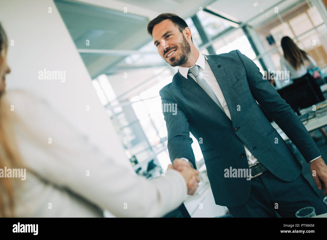Giovane imprenditore e la donna agitare le mani come hello in office ritratto Foto Stock