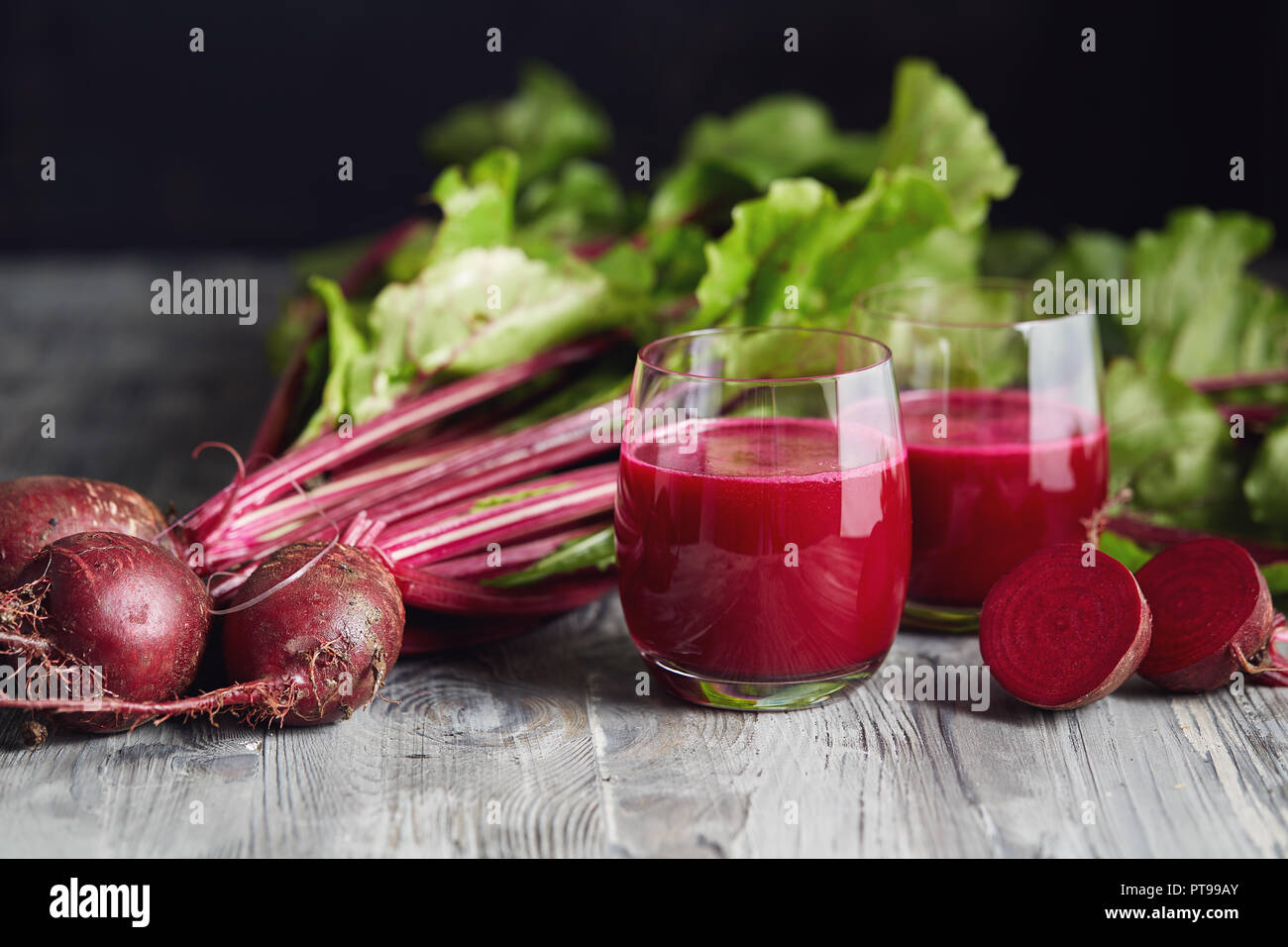 Detox succo con appena raccolto mazzetto di barbabietole. Le barbabietole fresche su un tavolo di legno. Foto Stock