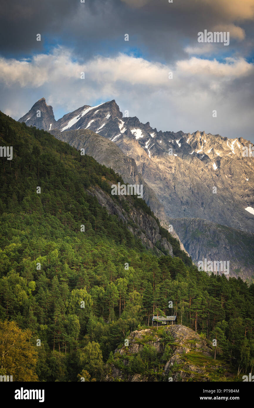 Piccola cabina nelle foreste di montagna, vista sulle montagne Romsdal. Area Åndalsnes, Norvegia. Foto Stock