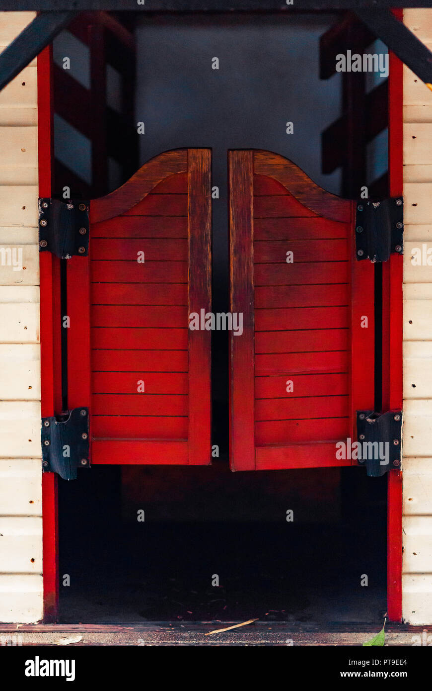 Chiuso rosso Western Saloon porte su un bianco parete in legno su un  luminoso giorno di sole Foto stock - Alamy