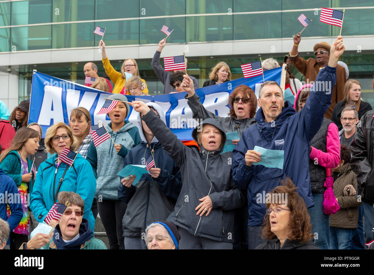 Detroit, Michigan STATI UNITI D'America - 7 Ottobre 2018 - sventolando bandierine americane, Cattolica riuniti presso il fiume Detroit, il confine internazionale con il Canada, per pregare il rosario. Esso è stato parte del rosario da costa a costa, durante la quale circa mille gruppi cattolici riuniti a coste degli Stati Uniti, confini e in altri luoghi pubblici per pregare il rosario. Credito: Jim West/Alamy Live News Foto Stock