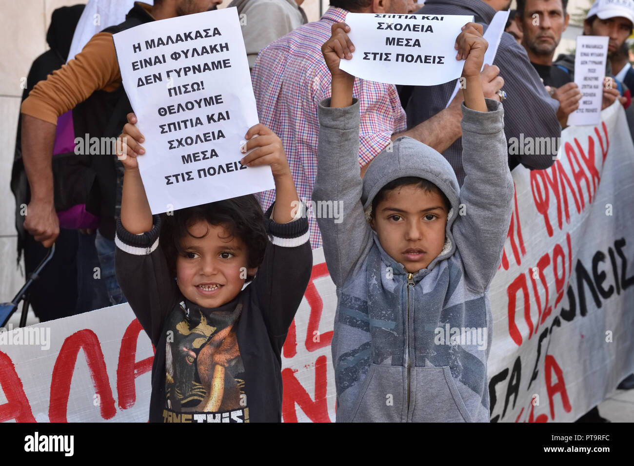 Pireo, Grecia. 8 Ott 2018. I rifugiati tenendo un banner e constata che leggere 'Malakasa è una prigione. Non ci torneremo. Vogliamo case e scuole all'interno di città", protesta contro le condizioni di vita disagiate a Malakasa camp davanti al Ministero della politica migratoria nel porto del Pireo, Grecia. Credito: Nicolas Koutsokostas/Alamy Live News. Foto Stock