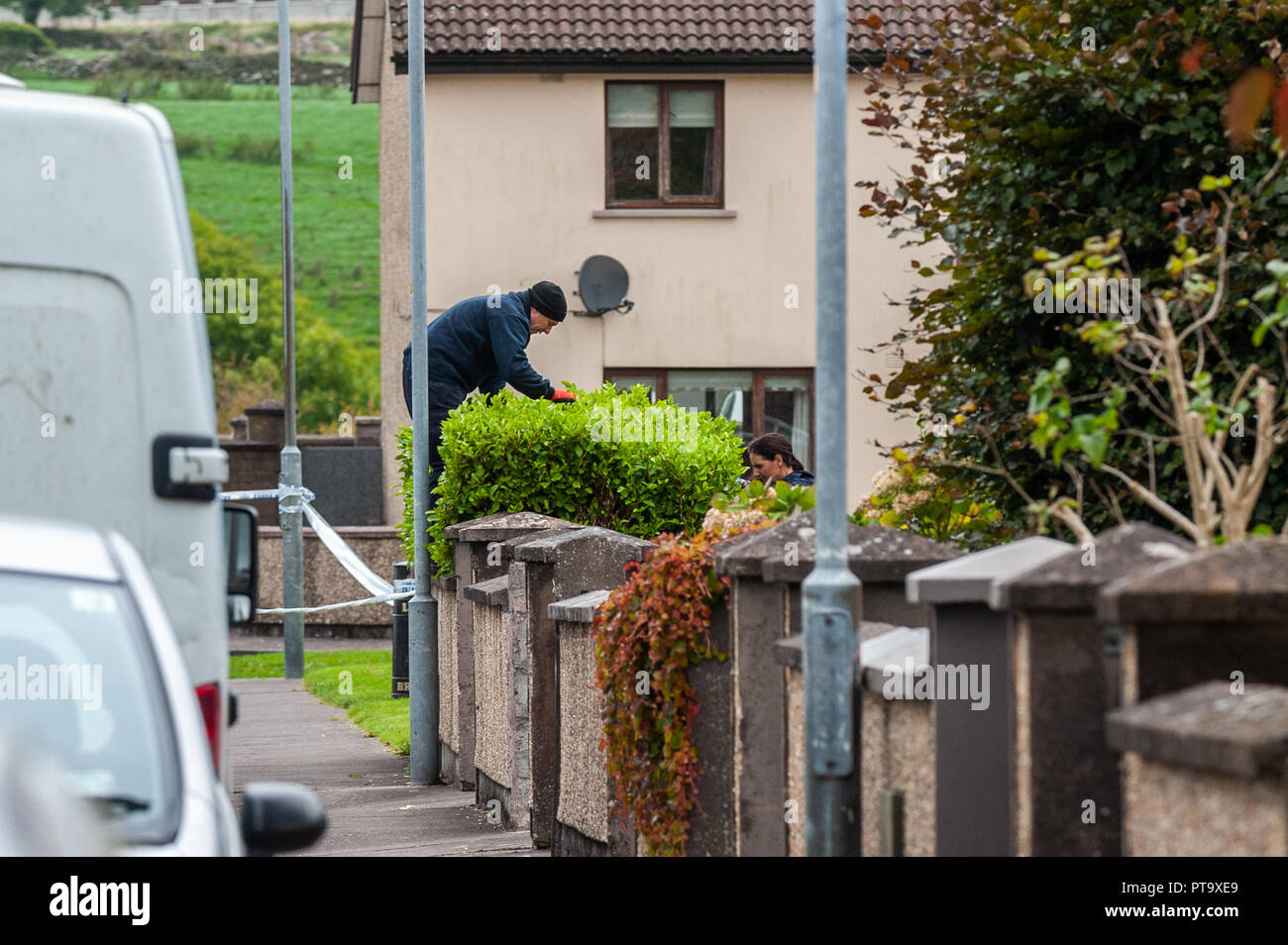 Macroom, West Cork, Irlanda. 8 Ott 2018. Un Garda cerca un cespuglio di fronte alla casa della vittima dell'omicidio, che è stato chiamato localmente come Timmy Foley 44 anni. Credit: Notizie dal vivo di AG/Alamy. Foto Stock
