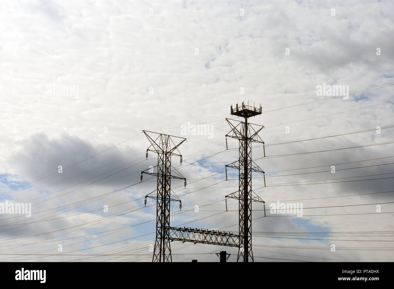 Alta tensione potenza elettrica torre e i cavi su un poco nuvoloso giorno Foto Stock