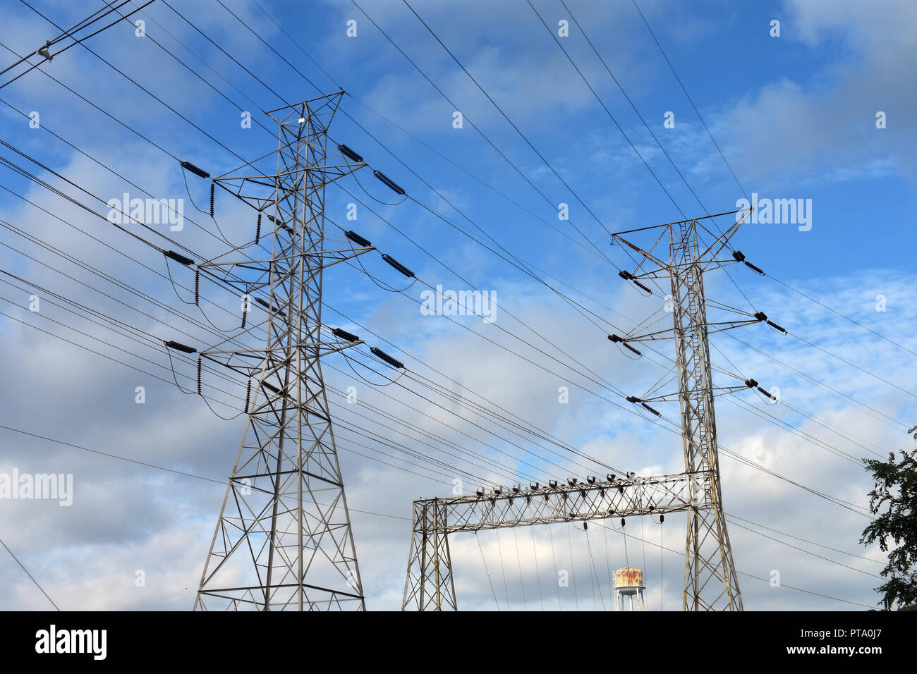 Alta tensione potenza elettrica torre e i cavi su un poco nuvoloso giorno Foto Stock