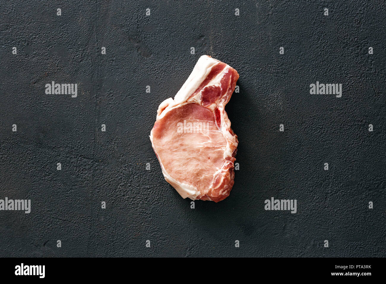 La carne di maiale osso su sfondo nero in vista superiore Foto Stock