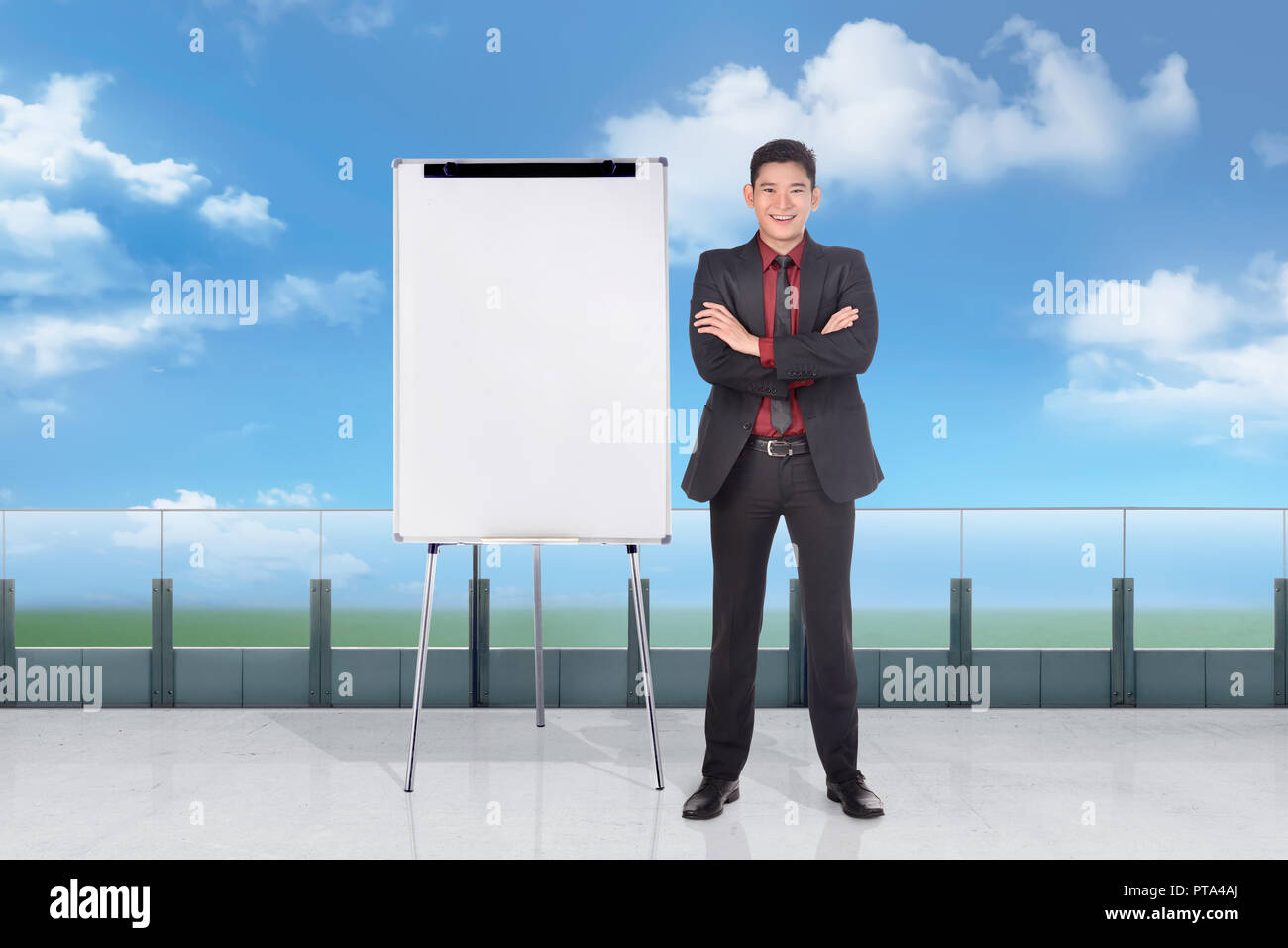 Handosme imprenditore asiatici in piedi con la lavagna vuota al di fuori ufficio Foto Stock