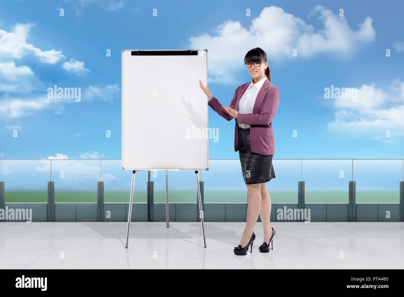 Pretty asian imprenditrice che mostra la lavagna vuota per copyspace Foto Stock