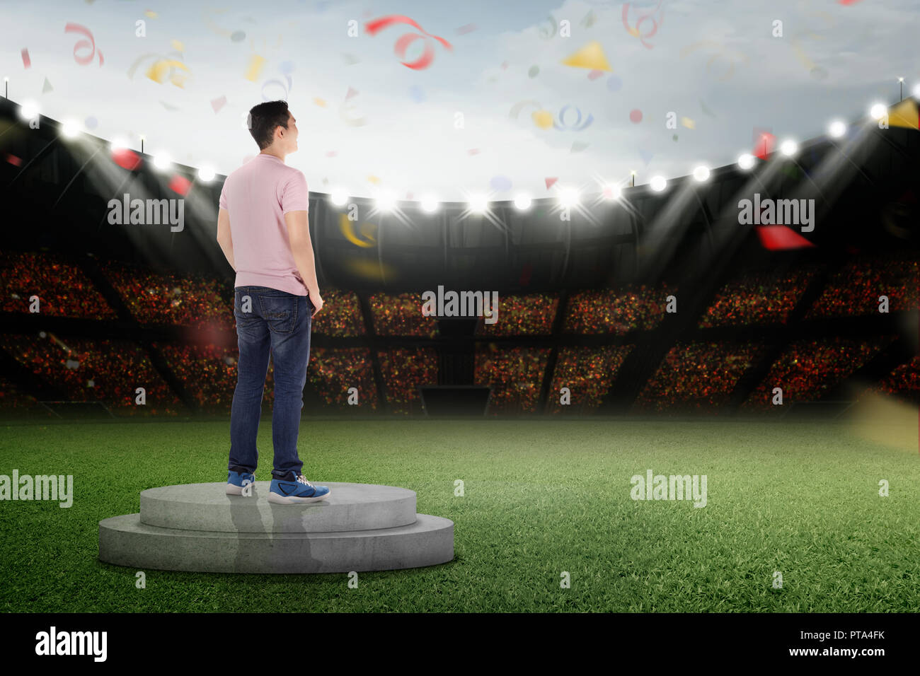 Felice uomo asiatico in piedi sul podio con i confetti in aria Foto Stock