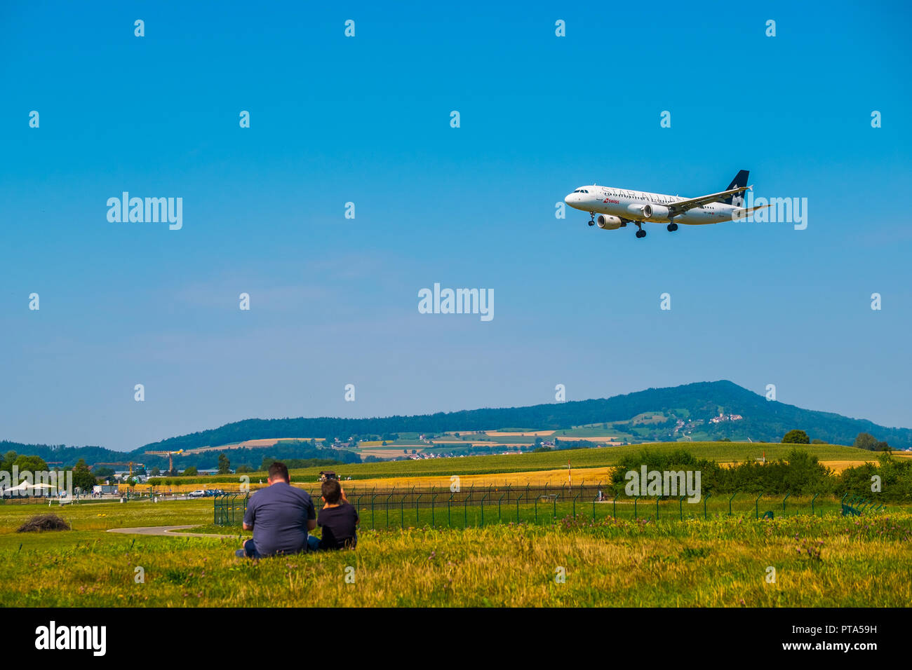 Padre e figlio guardando gli aerei di atterraggio all'aeroporto di Zurigo al giorno di sole tempo Foto Stock