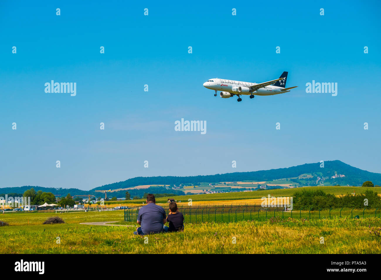 Padre e figlio guardando gli aerei di atterraggio all'aeroporto di Zurigo al giorno di sole tempo Foto Stock