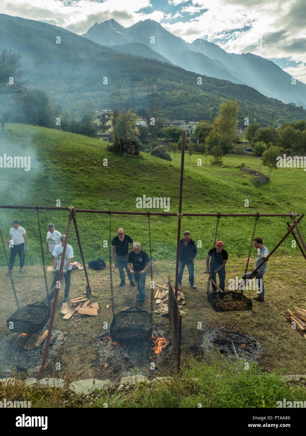 Essendo di castagne arrostite in enormi padelle durante la sagra della castagna nel comune di Fenis in Valle d'Aosta regione NW Italia Foto Stock