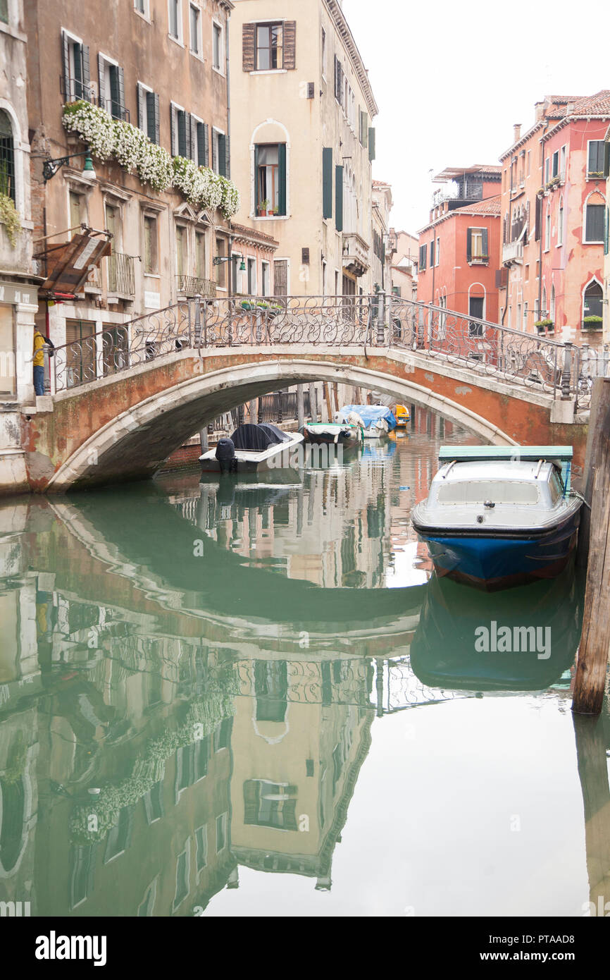 Un canale per via navigabile in Venezia , Italia con ponti e barche lungo di essa Foto Stock