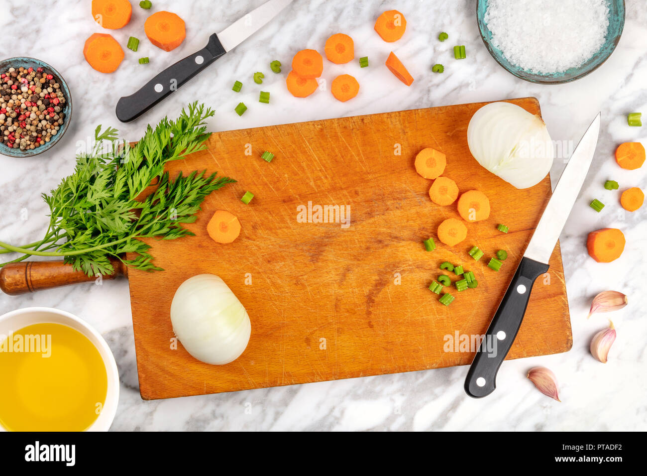 Tempo di preparazione o di mise en place. Un overhead foto professionali dei coltelli chef, ripresa dall'alto su un tagliere con un trito di verdure e spezie, sul marmo di un piano di cottura con un posto per il testo Foto Stock