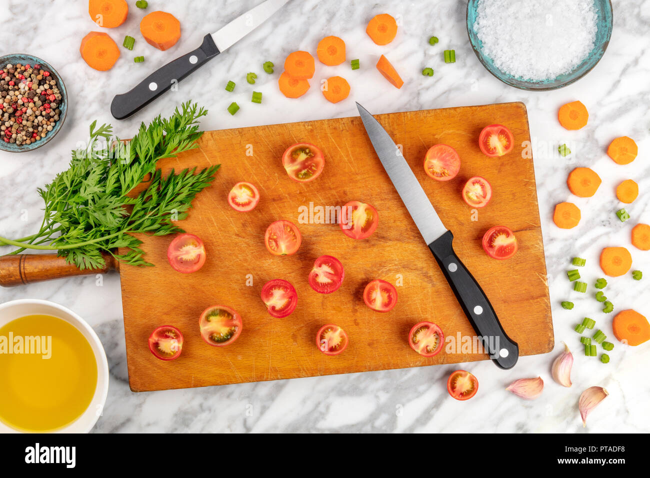 Tempo di preparazione o di mise en place. Un overhead foto professionali di un Coltello per cuoco, ripresa dall'alto su un tagliere con un trito di verdure e spezie, su un marmo Superficie di cottura Foto Stock