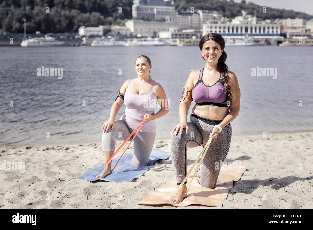 Bella donne positive utilizzando l'esercizio delle bande per la formazione Foto Stock