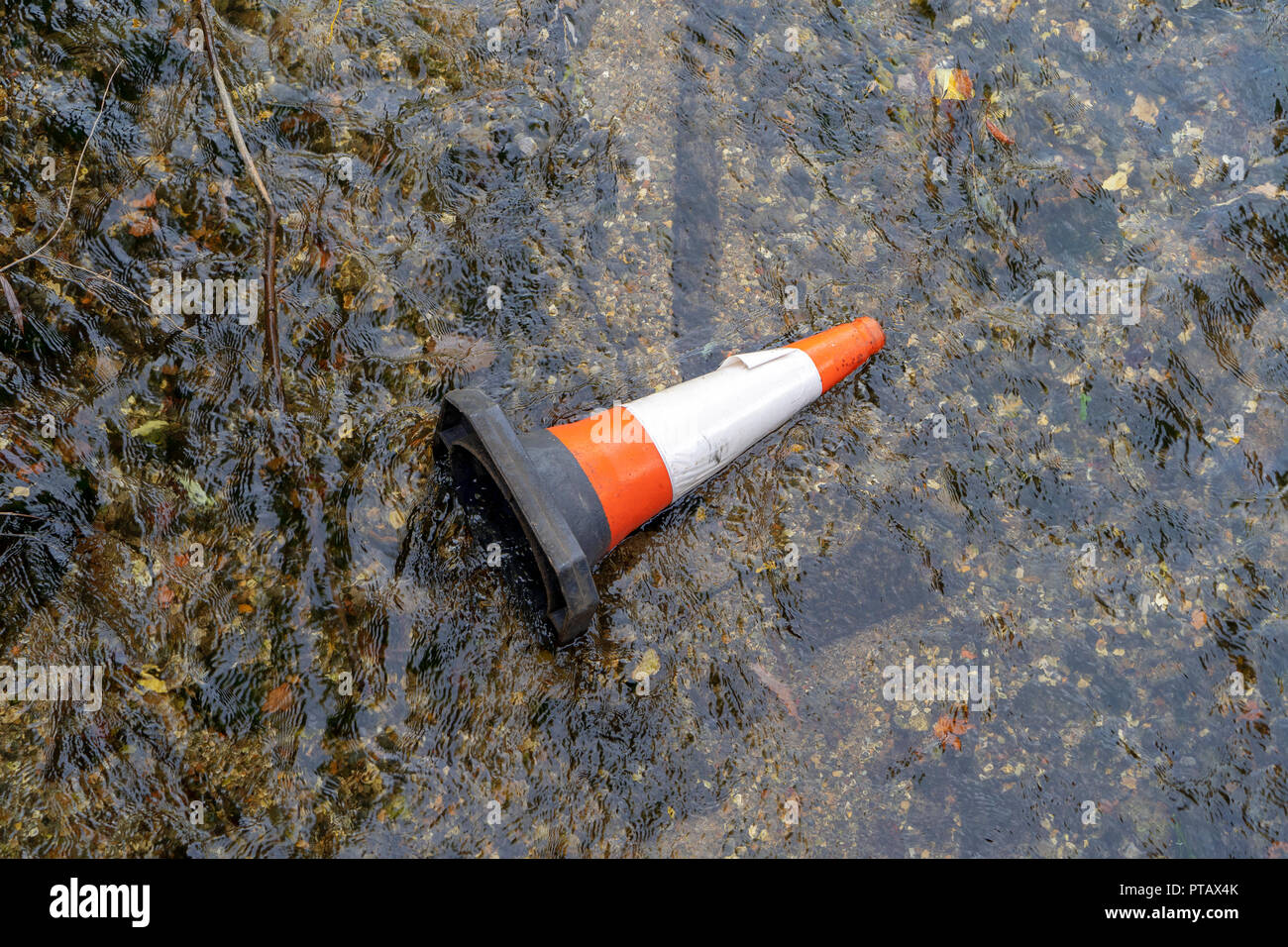 Cono stradale gettato nel fiume Foto Stock