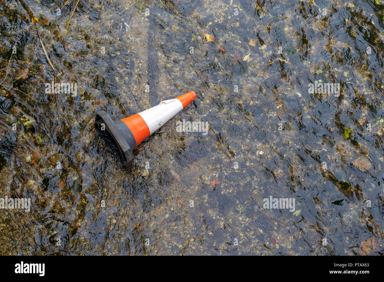 Cono stradale gettato nel fiume Foto Stock