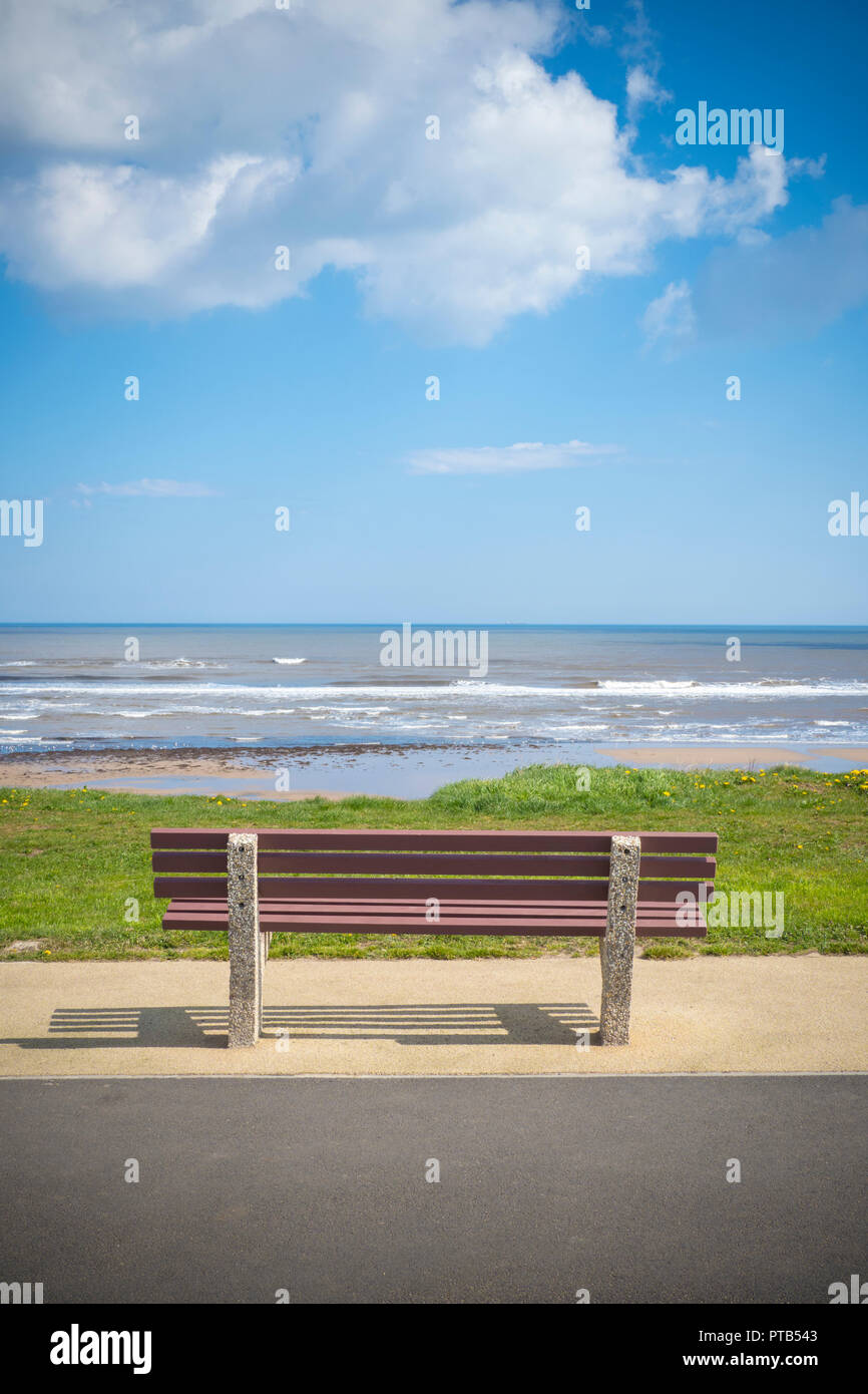 Cemento e panca di legno che si affaccia sul mare Foto Stock