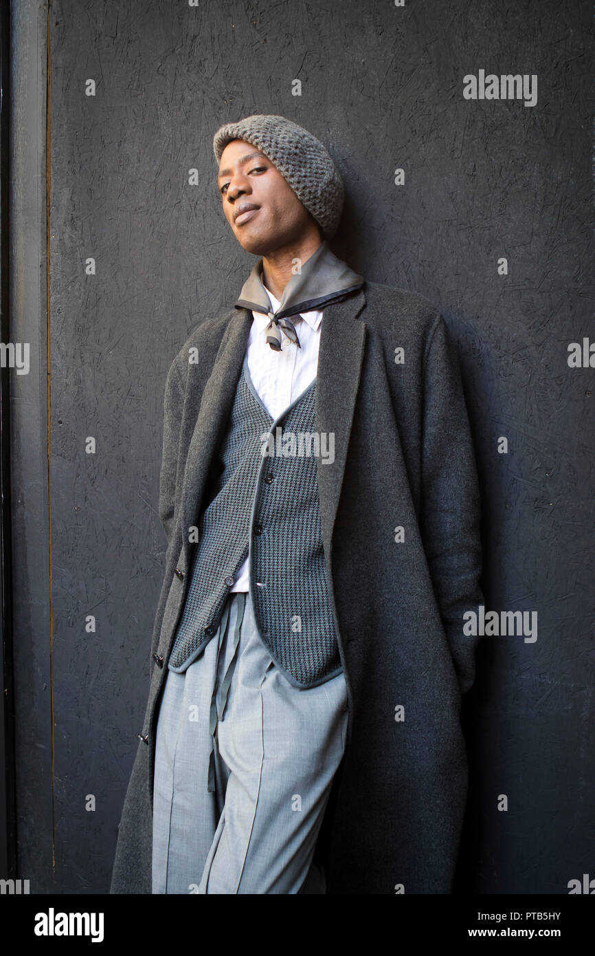 LONDON, Regno Unito - 14 settembre 2018: la gente per strada durante la London Fashion Week. Un uomo in un cappotto grigio di flanella di lana, pantaloni, giubbotto e beret Foto Stock