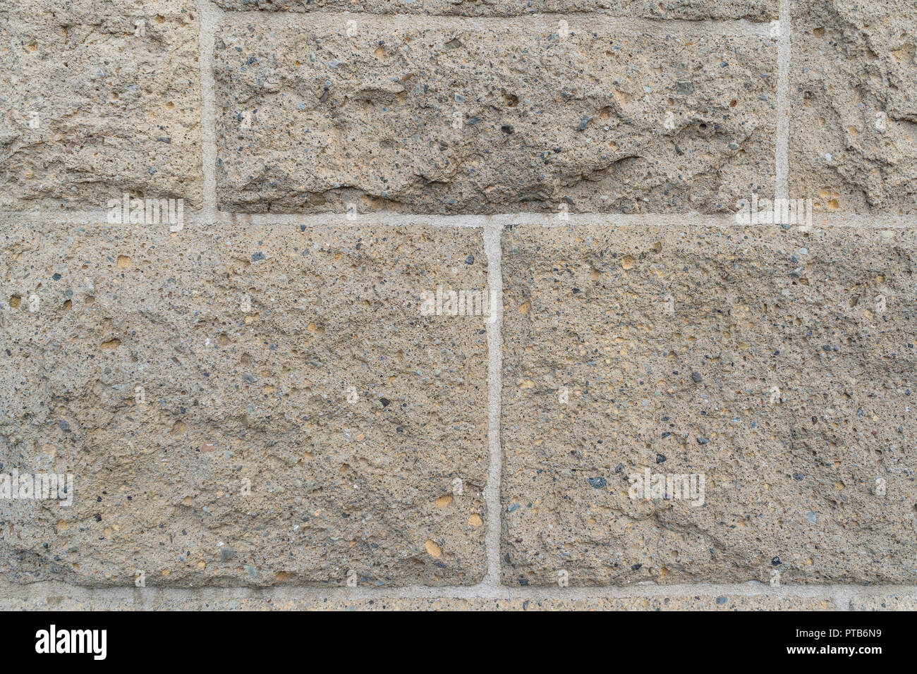 Close up su ruvida pietra rettangolare di mattoni di dimensioni diverse nella parete collegati da bianco luminoso con boiacca Foto Stock