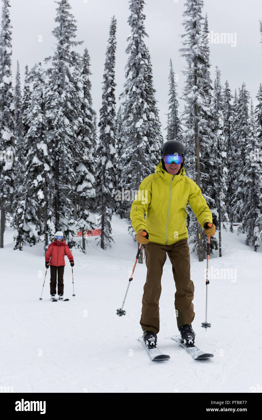 Sciatore giovane sciare sul paesaggio innevato Foto Stock