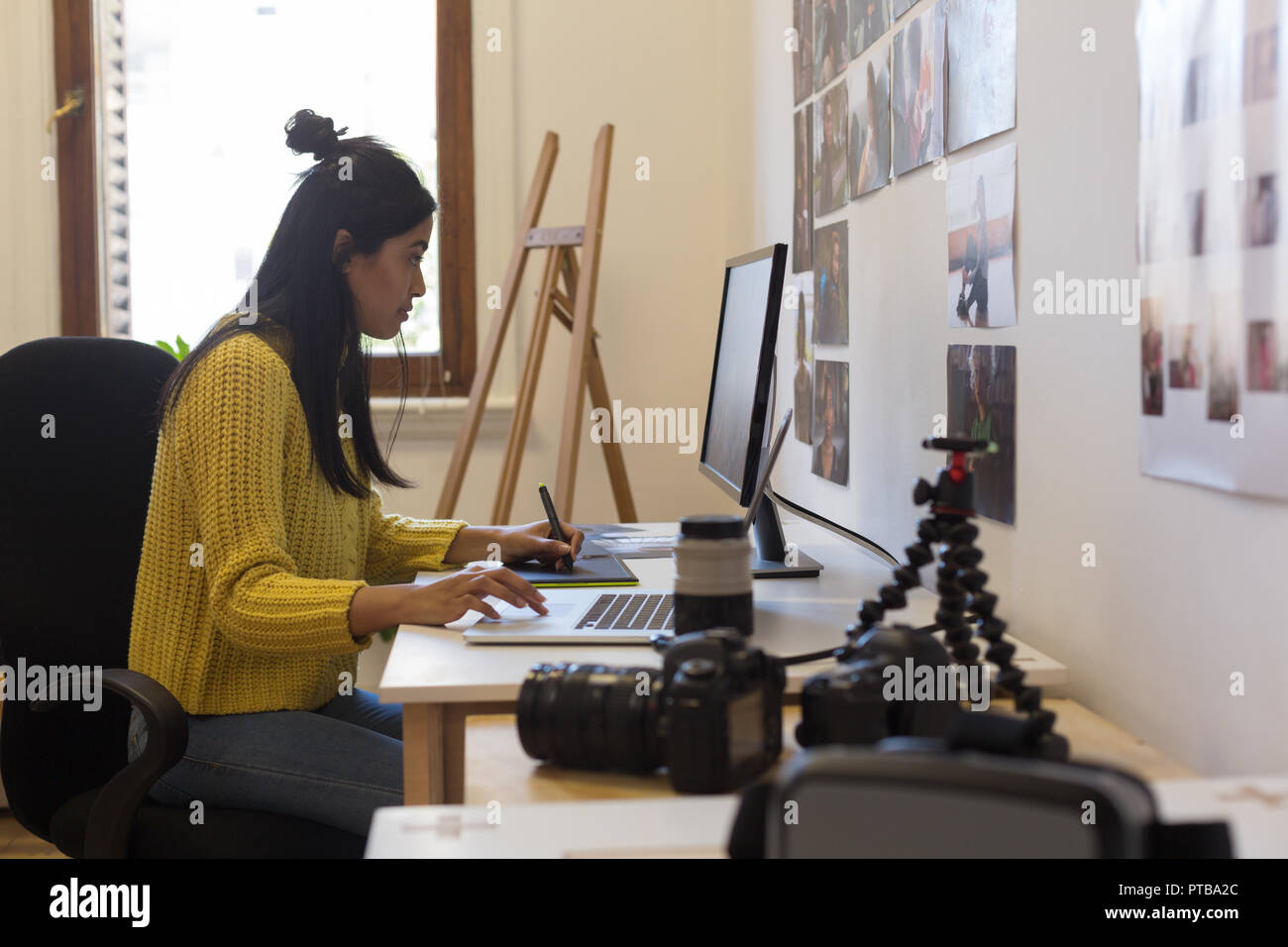 Graphic designer che lavora sulla tavoletta grafica e il computer portatile in desk Foto Stock