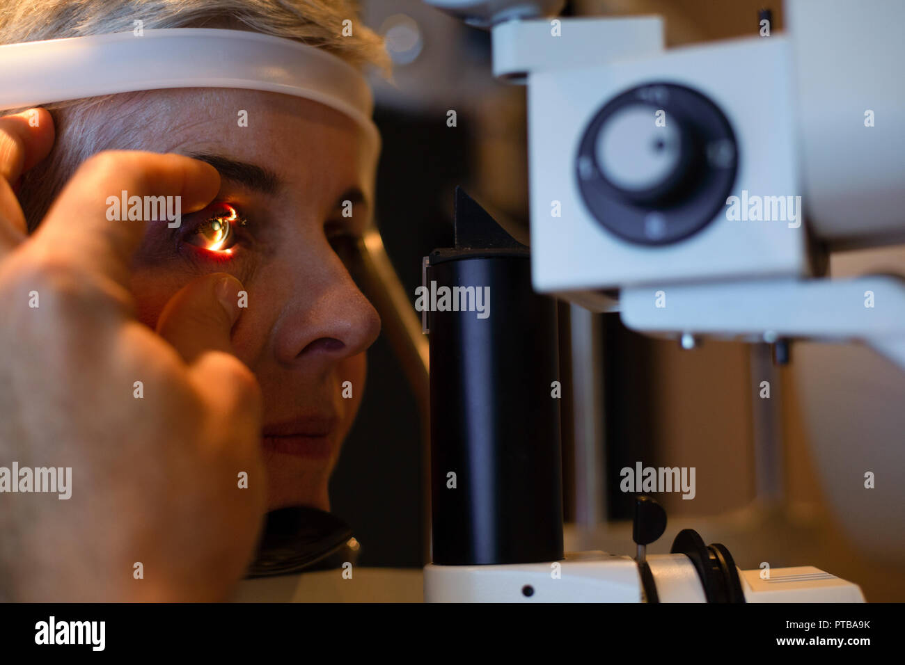 All'ottico optometrista esaminando gli occhi del paziente con lampada a fessura in clinica Foto Stock