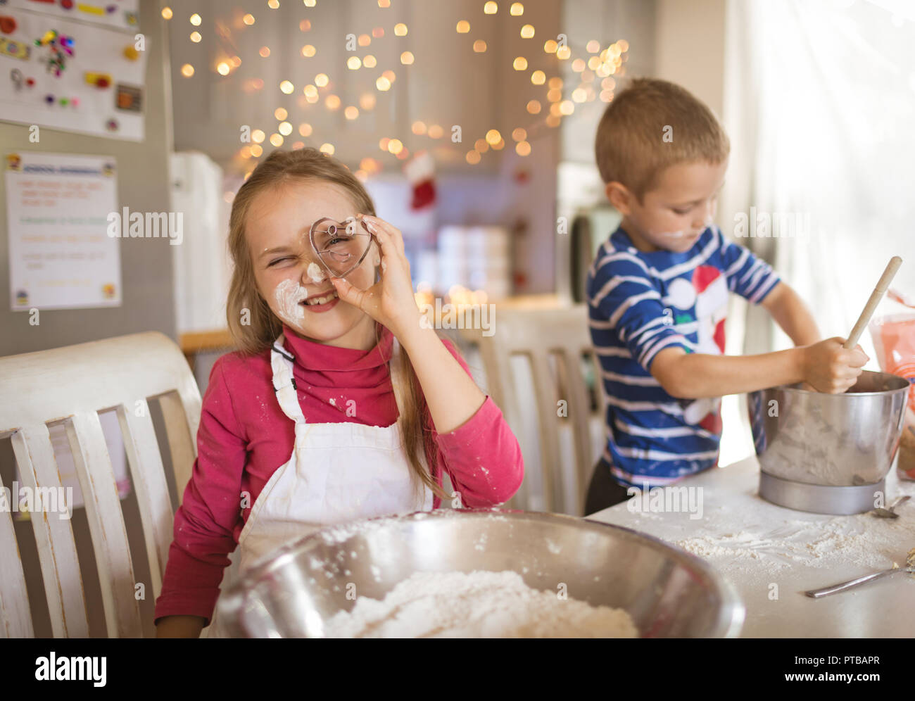 Ragazza che mostra una forma di cuore cookie cutter Foto Stock