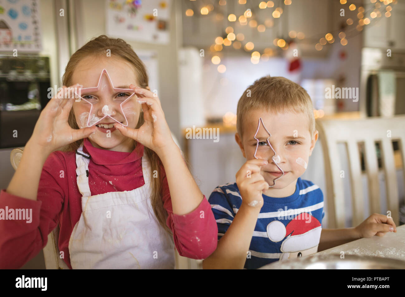 Ragazzo e una ragazza che mostra cookie cutters Foto Stock