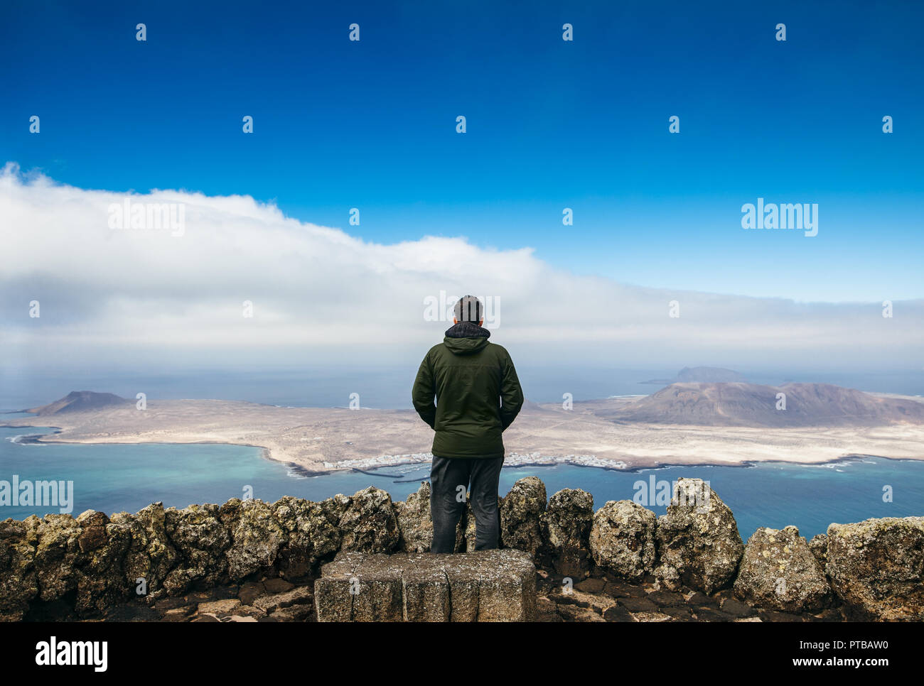 Traveler uomo godendo di bellissimi paesaggi marini a viewpoint sull isola. Concetto di viaggio. Inverno nelle isole Canarie. Foto Stock