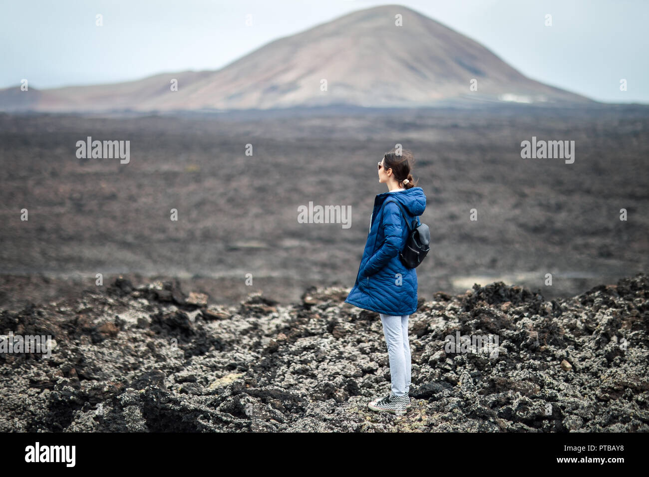 Traveler donna unica godere di paesaggi vulcanici del Parco Nazionale di Timanfaya, Lanzarote, Isole Canarie. Foto Stock