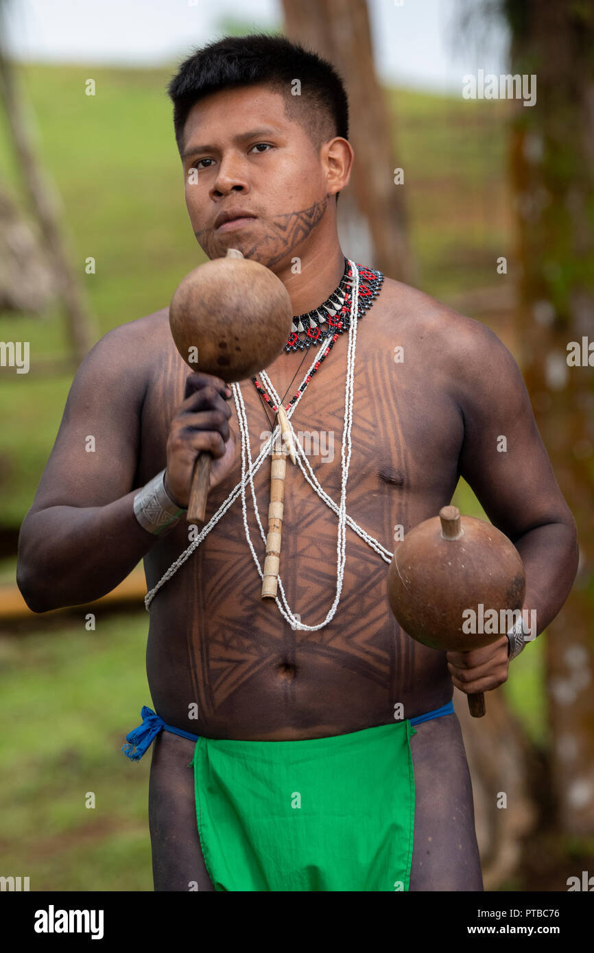America centrale, Panama, Gatun Lago. Embera villaggio indiano. Tipico tatuato Embera maschio abitante la riproduzione di musica. Foto Stock