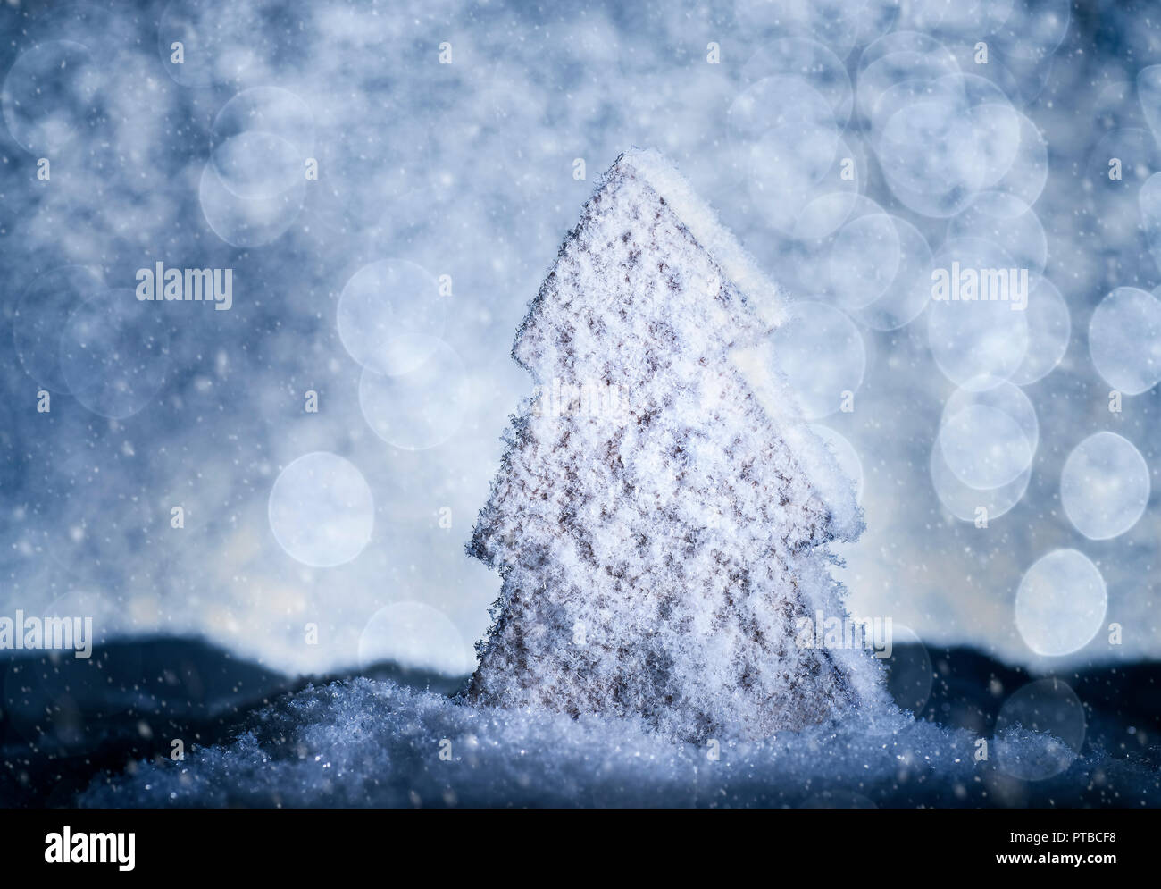 Albero di natale con la neve e il bokeh in luce blu Foto Stock