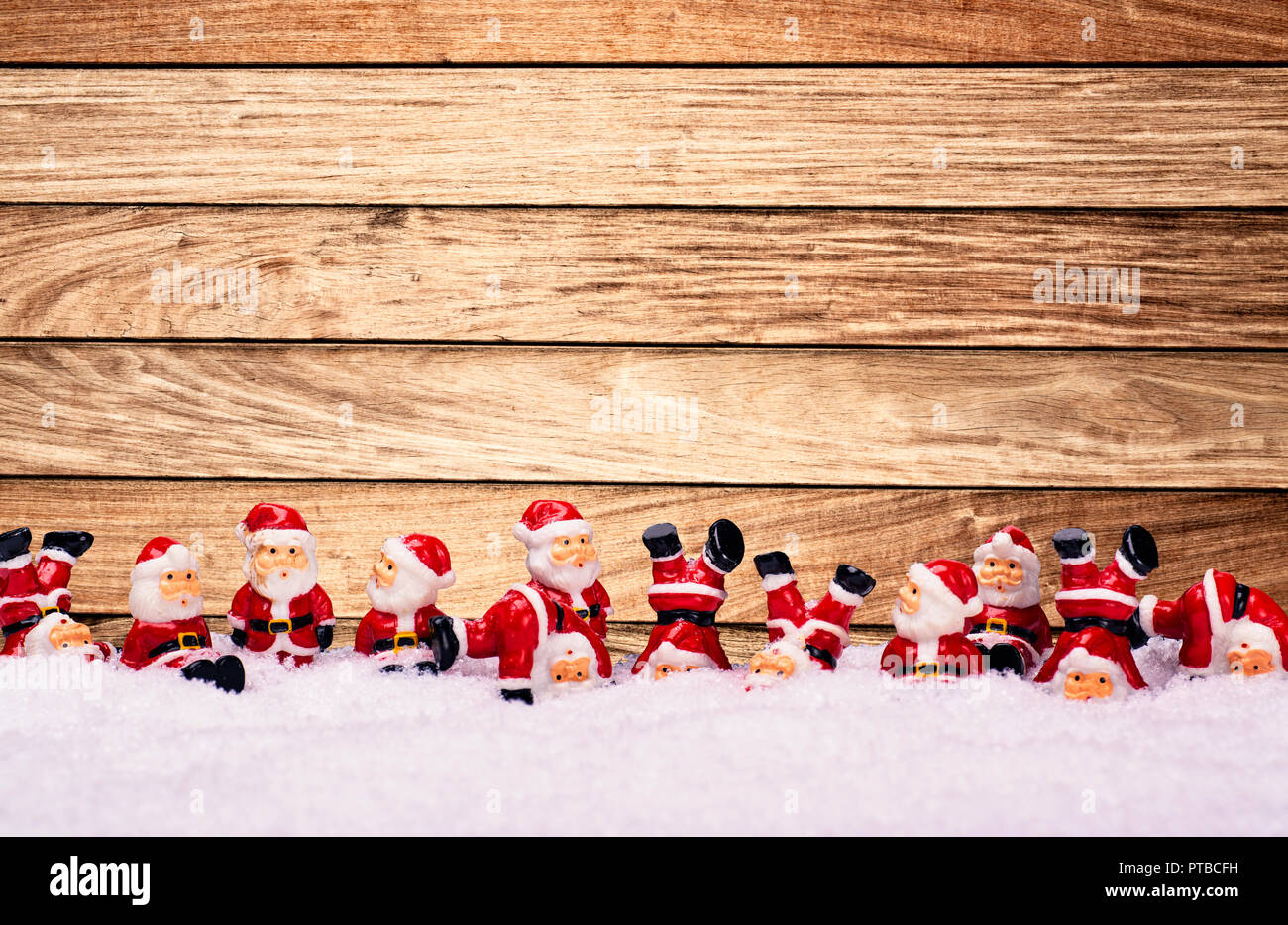 Un gran numero di Santa Claus figure di fronte ad una parete in legno Foto Stock
