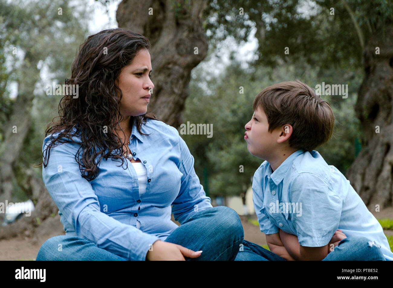 Ritratto di una madre scolding a sua figlia del bambino seduto sul pavimento nel soggiorno a homePortrait di una madre scolding a Suo Figlio seduto sull'erba nel parco. Foto Stock