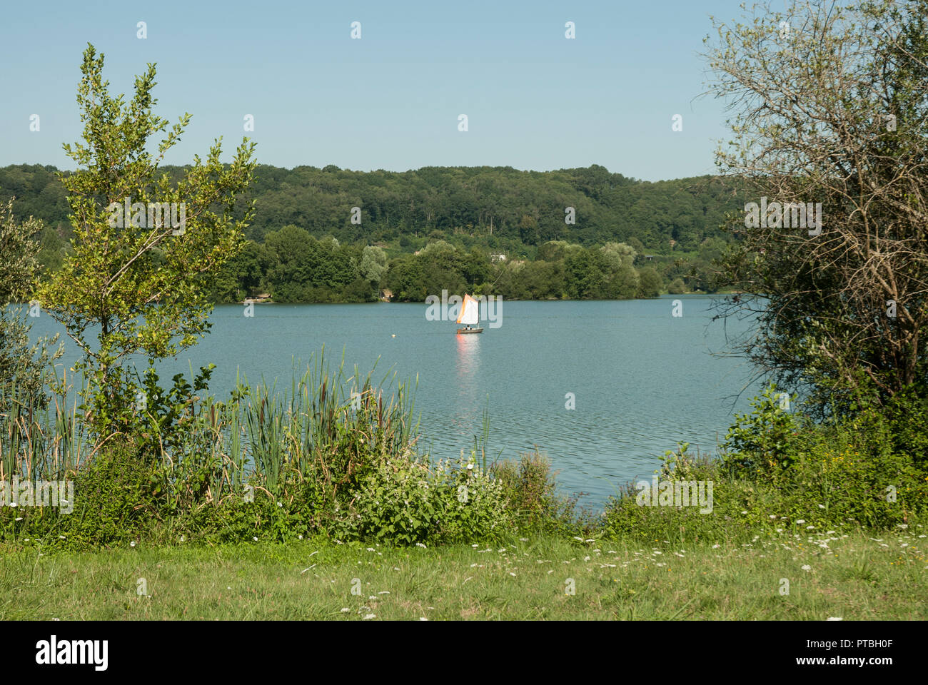 Il Lac des Varennes a Marcon, Pays de la Loire, con nuoto, canoa e barca a vela, in estate il sole e cieli blu. Foto Stock