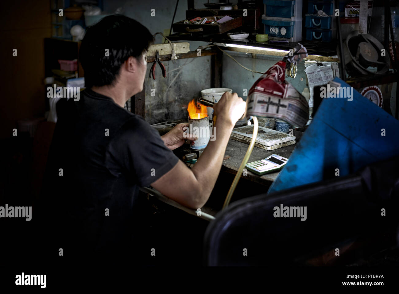 Officina orafa. Fondere l'oro in un crogiolo ceramico resistente al calore e utilizzando una torcia ossiacetilenica. Industria gioielleria in Thailandia. Asia Foto Stock