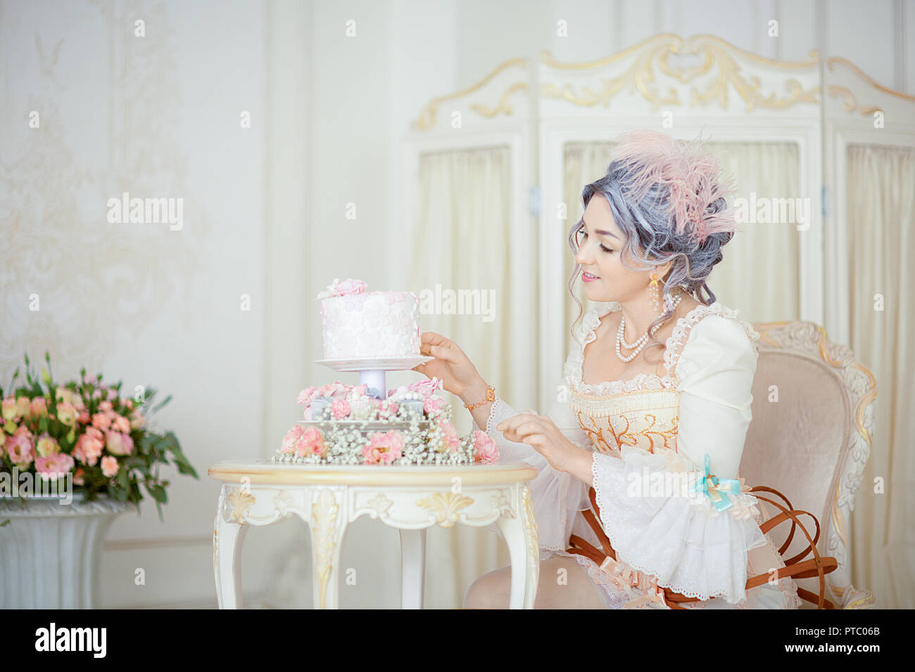 Bella donna grayhead in abito rococò in posa di fronte storico di sfondo  mentre la decorazione di una torta di Halloween Foto stock - Alamy