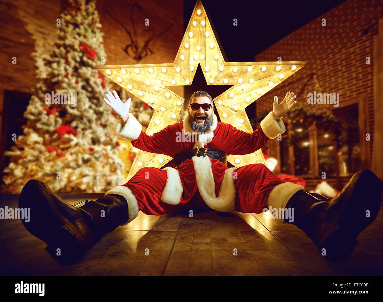 Funny santa claus in camera con la grande stella di Natale. Foto Stock