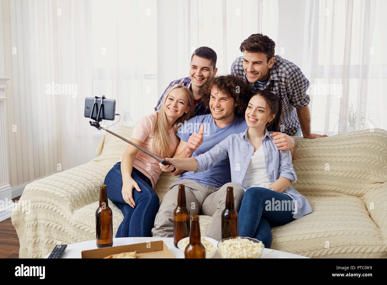 Gruppo di amici facendo selfie telefono in ambienti chiusi. Foto Stock