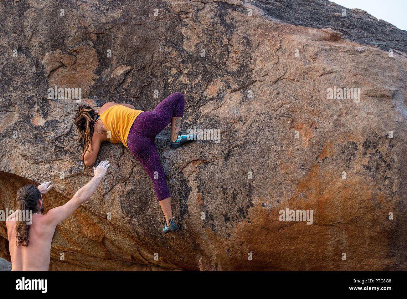 Una femmina di scalatore pratiche la sua arrampicata boulder competenze, Hampi, India. Foto Stock