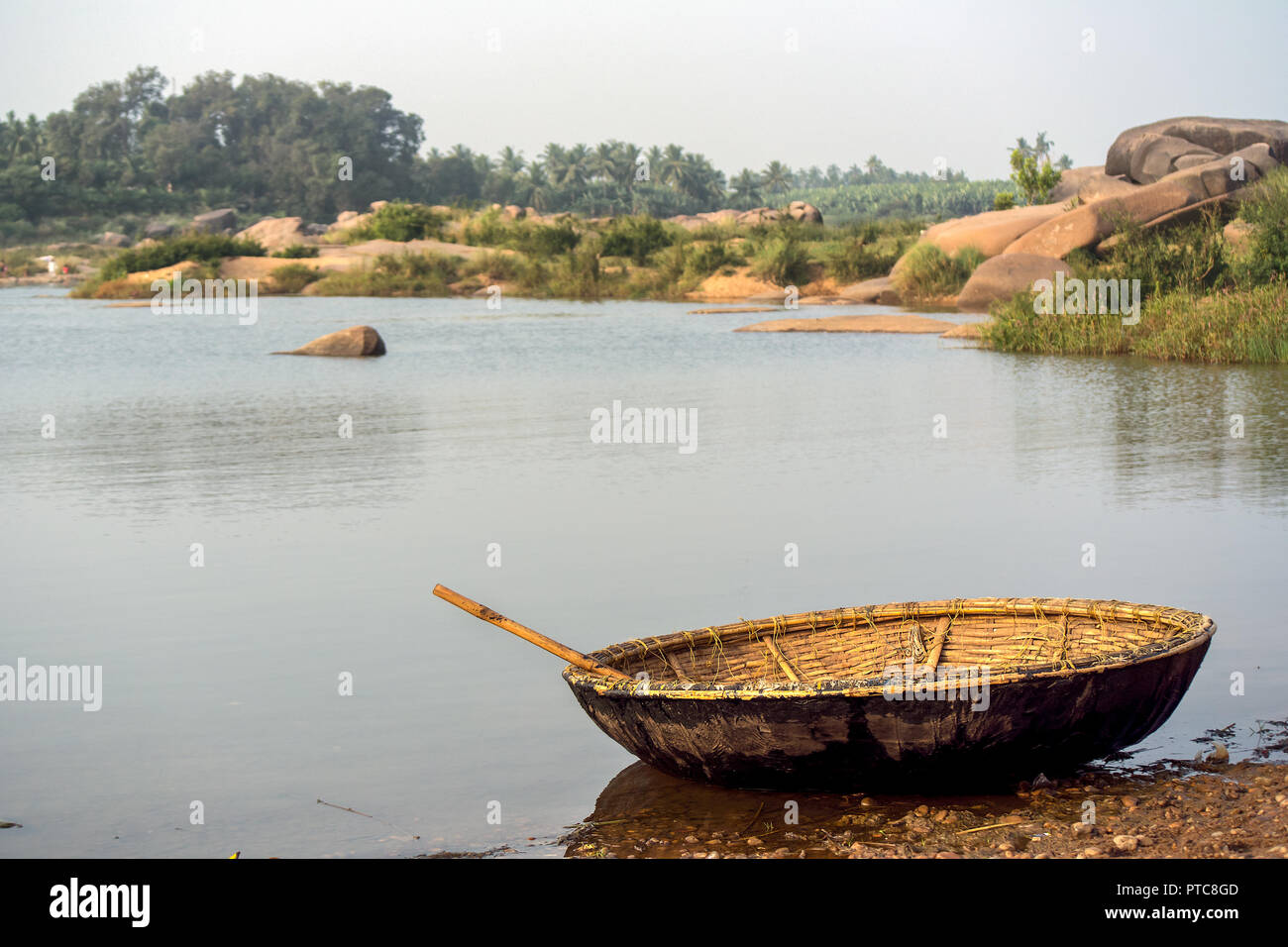 Un fatto a mano tradizionale barca Coracle poggia sulle spalle poco profonde del fiume Tungabhadra, Hambi, India. Foto Stock