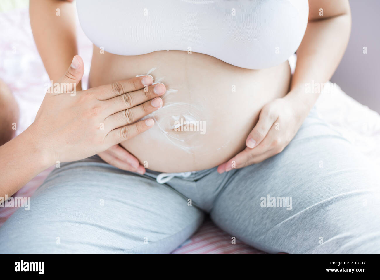 Asian donna incinta con grande pancia. Rilassarsi a casa con il marito. Foto Stock